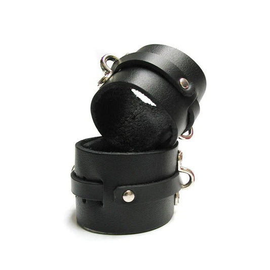 black leather wrist cuffs, with metal details and d-rings stacked