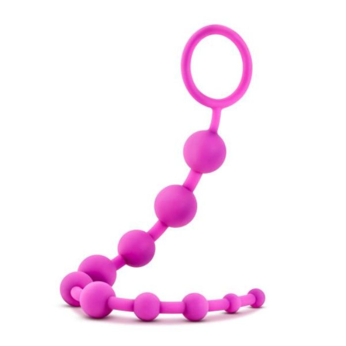 hanging pink string of Silicone Anal Beads with 10 beads starting from smallest to largest and increasing in size up to the removal ring