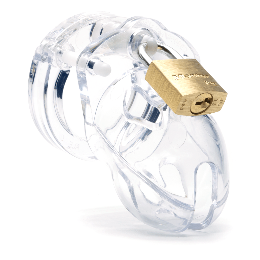 Front view, with tip angled to the right of a fully-assembled clear Mr. Stubb penis chastity cage. Three white locking pins connect the base ring to the penis cage and a brass padlock is secured through a hole on the center locking pin.