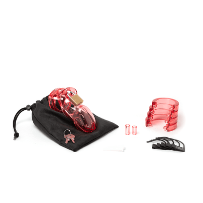 Fully assembled transparent red CB-3000 chastity cage sitting on black cotton storage pouch with 2 metal keys to left. 2 white locking pins, 2 transparent red spacers, 4 transparent red U-rings and 5 black plastic locks lay displayed to the right.