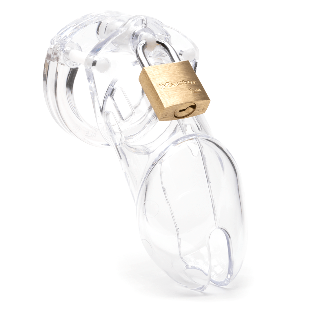Front view, with tip angled to the right of a fully-assembled clear CB-6000 penis chastity cage. Three white locking pins connect the base ring to the penis cage and a brass padlock is secured through a hole on the center locking pin.