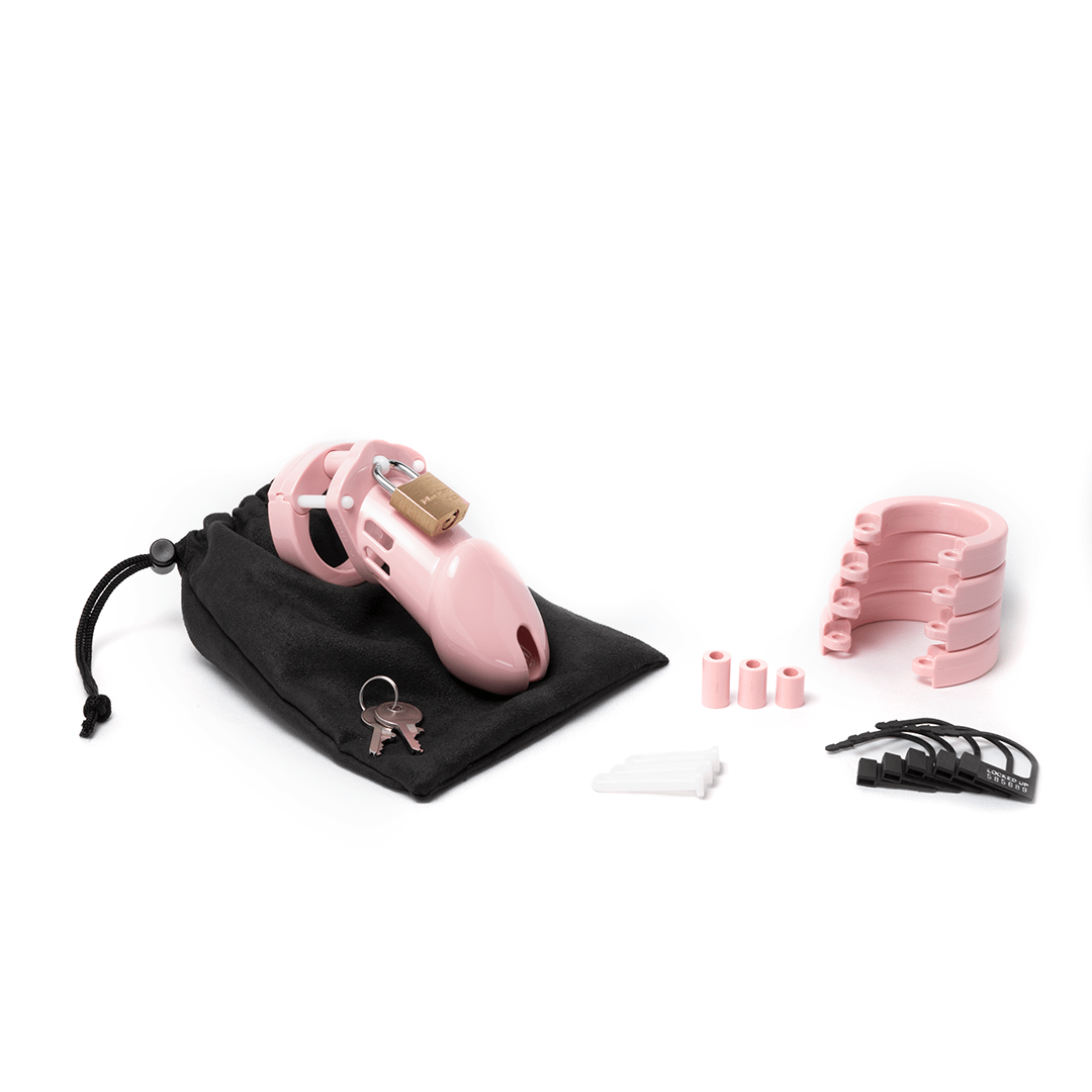 Fully-assembled pink CB-6000 chastity cage on a black cotton storage pouch with 2 metal keys to left. 3 pink spacers, 3 white locking pins, 4 pink stacked U-rings and 5 black plastic locks lay displayed on right.