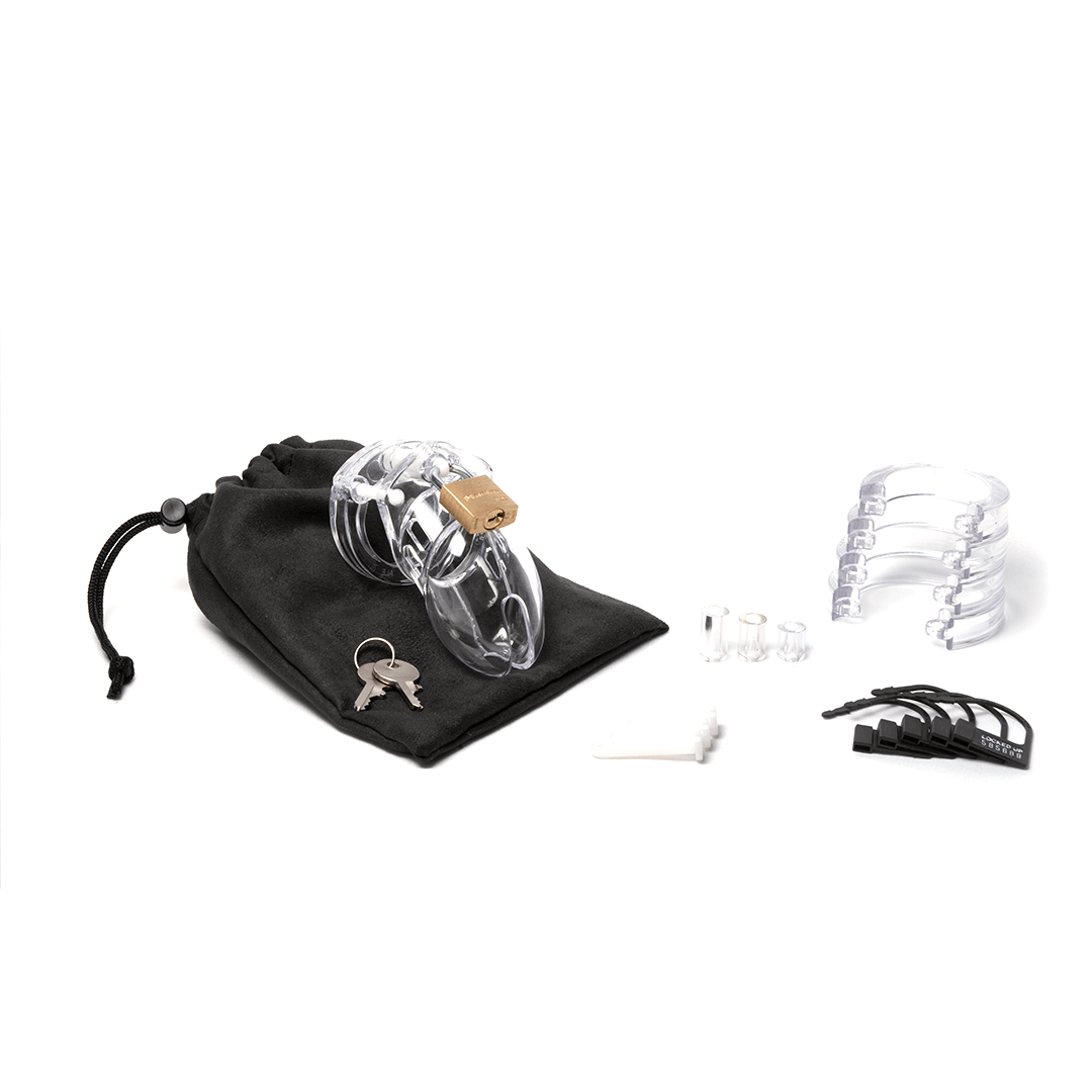 Fully-assembled clear CB-6000s chastity device on a black cotton storage pouch with 2 metal keys, 3 clear spacers, 3 white locking pins, 4 clear U-rings and 5 black plastic locks.