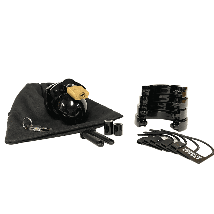 Fully-assembled black Mini-Me chastity cage on black storage pouch with 2 metal keys to left. 2 black spacers, 2 black locking pins, 4 black stacked U-rings and 5 black plastic locks sit displayed on right.