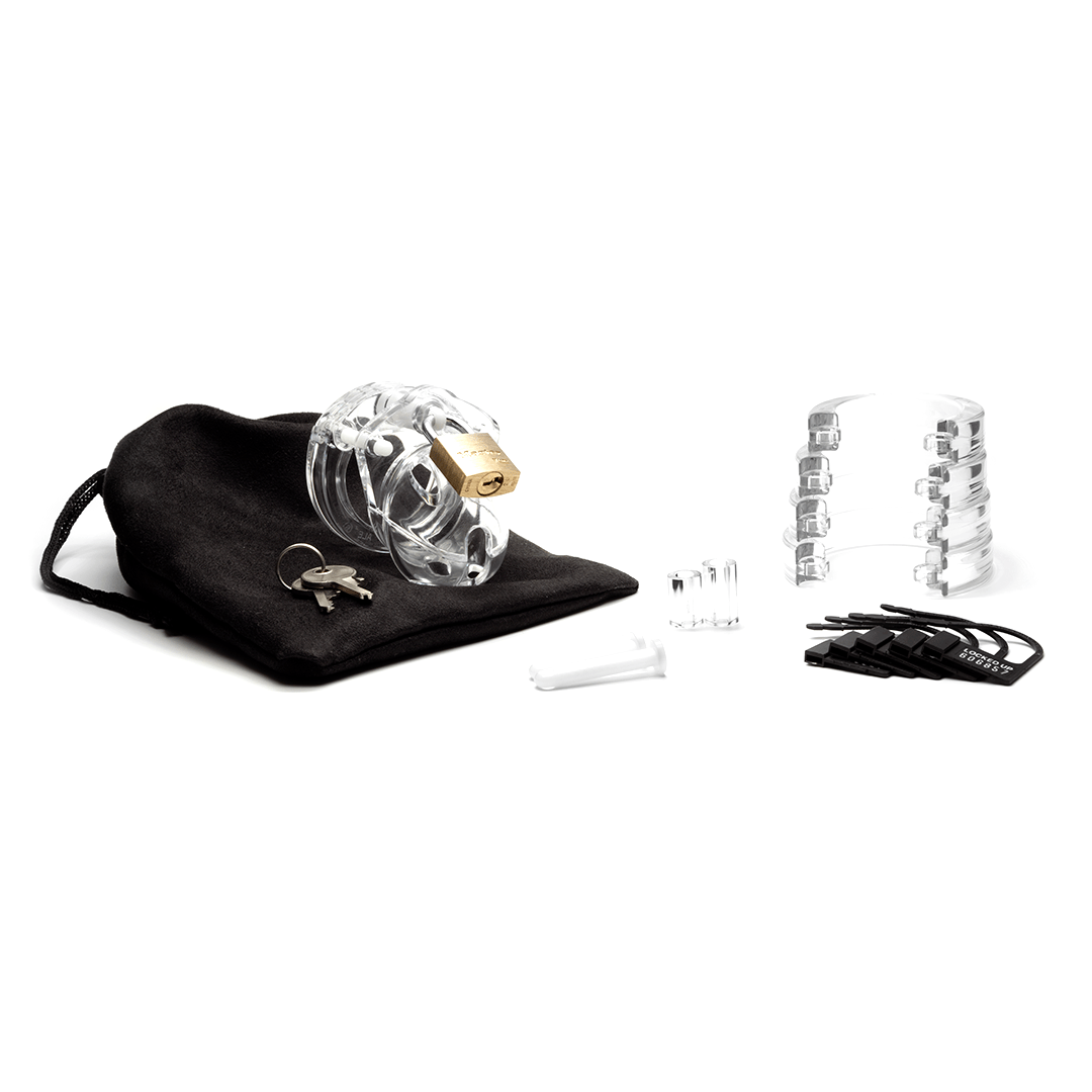 Fully-assembled clear Mini-Me chastity cage on black storage pouch with 2 metal keys to left. 2 clear spacers, 2 white locking pins, 4 clear stacked U-rings and 5 black plastic locks sit displayed on right.