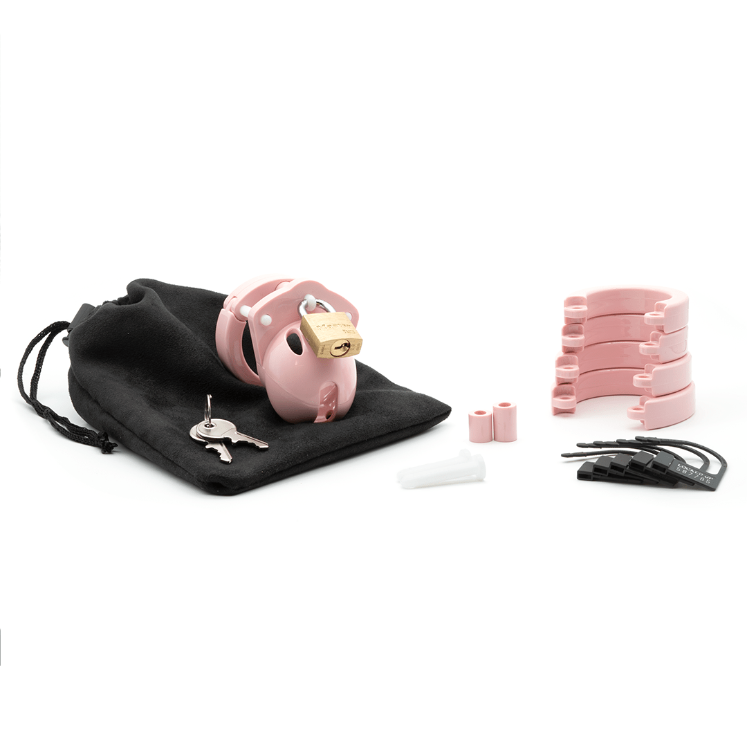 Fully-assembled pale bubblegum pink Mini-Me chastity cage on black storage pouch with 2 metal keys to left. 2 pink spacers, 2 white locking pins, 4 pink stacked U-rings and 5 black plastic locks sit displayed on right.