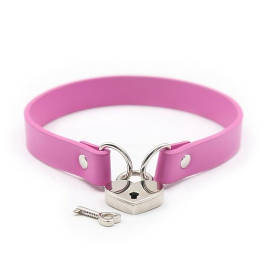pink pvc collar with metal loops on each end, linked together with a silver heart padlock, one key lying next to the lock